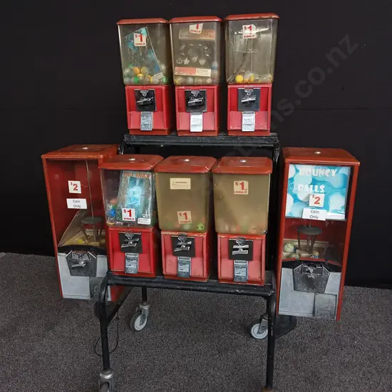 NORTHWESTERN BRAND TOY VENDING MACHINES 8 ATTACHED TO TROLLEY, ALL WITH COIN MECHANISM BUT NO KEYS