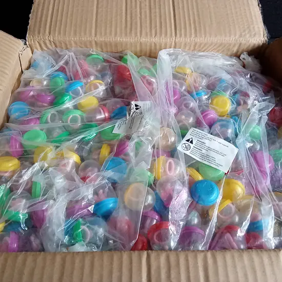BOX OF PLASTIC CAPSULES FULL OF COSTUME JEWELLERY FOR VENDING MACHINE