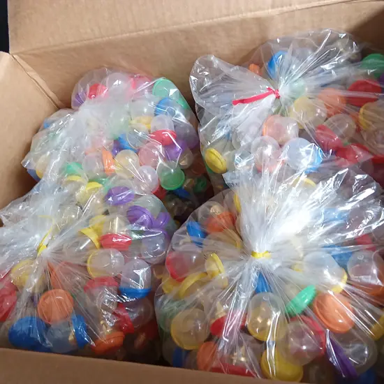BOX OF PLASTIC CAPSULES FULL OF COSTUME JEWELLERY FOR VENDING MACHINE