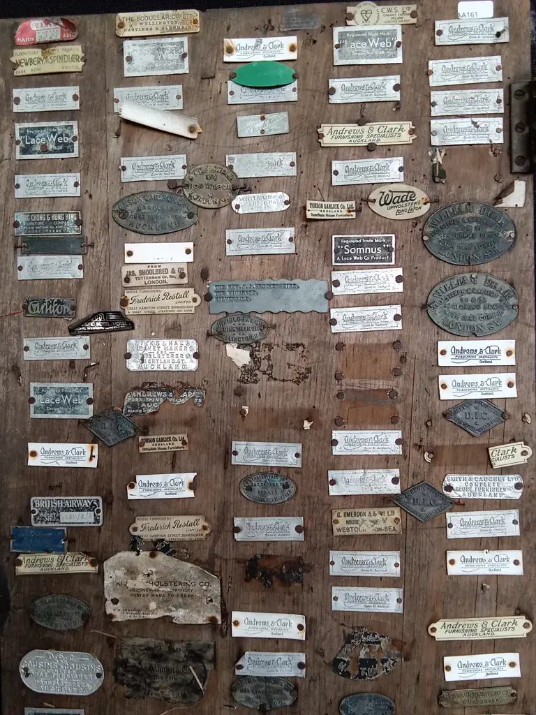DISPLAY BOARD FEATURING COLLECTION OF ANTIQUE AND VINTAGE UPHOLSTERY, FURNISHING AND BEDDING MANUFACTURER PLAQUES Image 1++