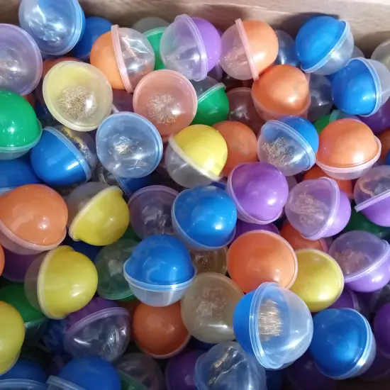 BOX OF PLASTIC CAPSULES FULL OF COSTUME JEWELLERY FOR VENDING MACHINE