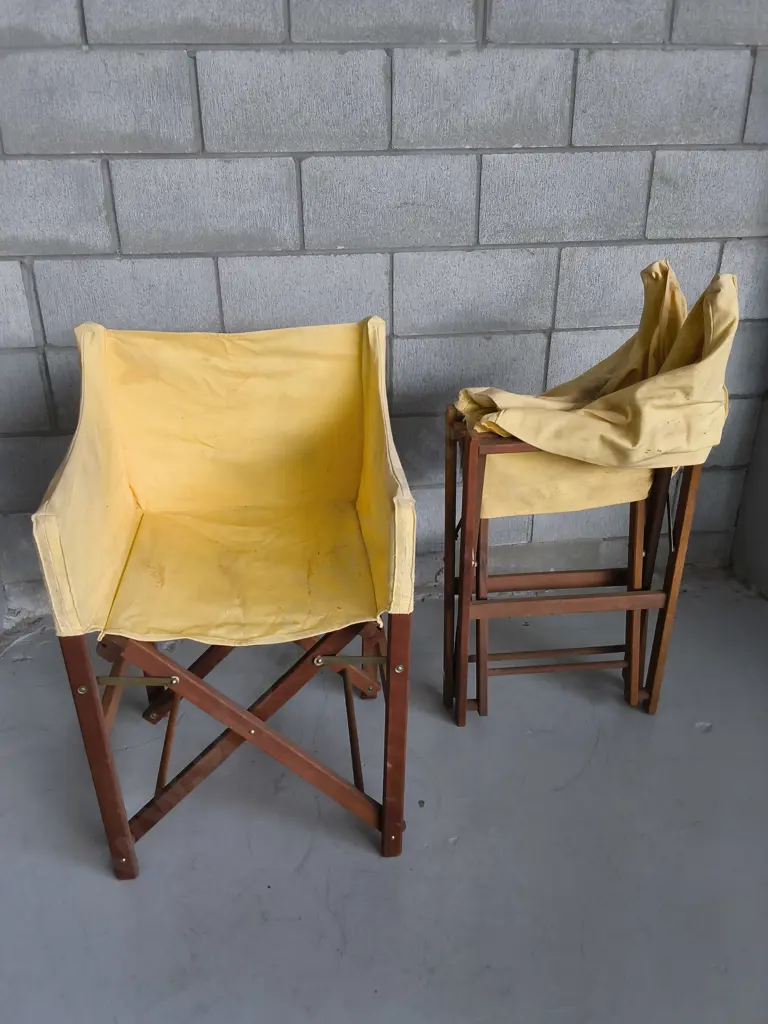 PAIR OF WOODEN FOLDING DIRECTORS CHAIRS WITH YELLOW FABRIC COVERS, DAMAGE PICTURED Image 1++