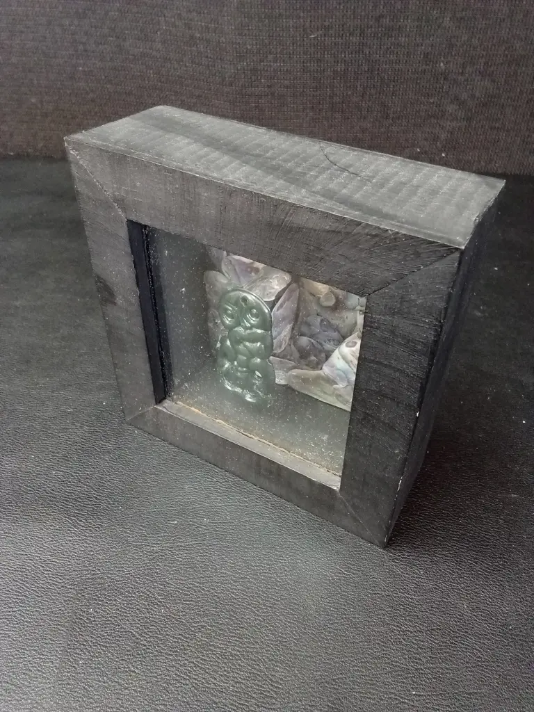 FRAMED SHADOW BOX WITH GREENSTONE HEI-TIKI AND PĀUA 11.5. X 11.5CM Image 1++